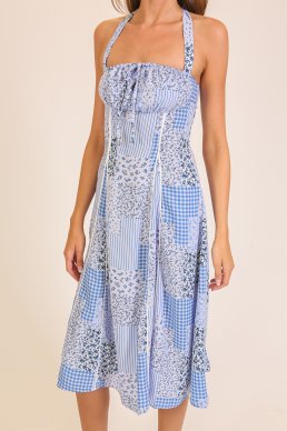 Woman wearing a blue and white patterned dress on a beige background