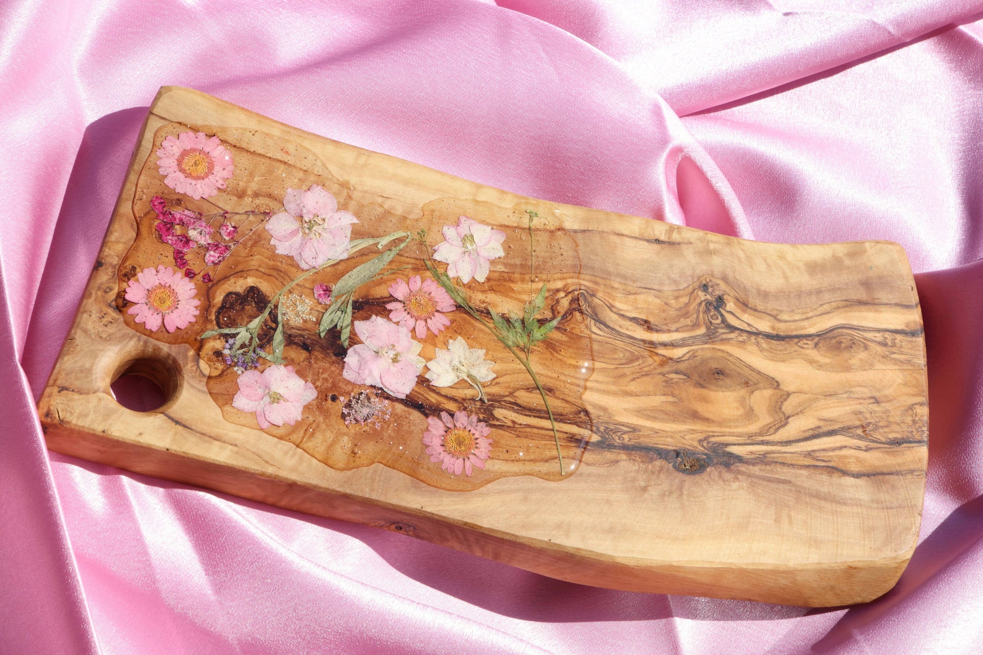 Wooden charcuterie board with flowers covered in resin
