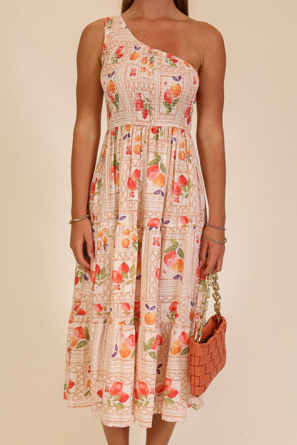 Woman wearing a floral one-shoulder dress with a beige background